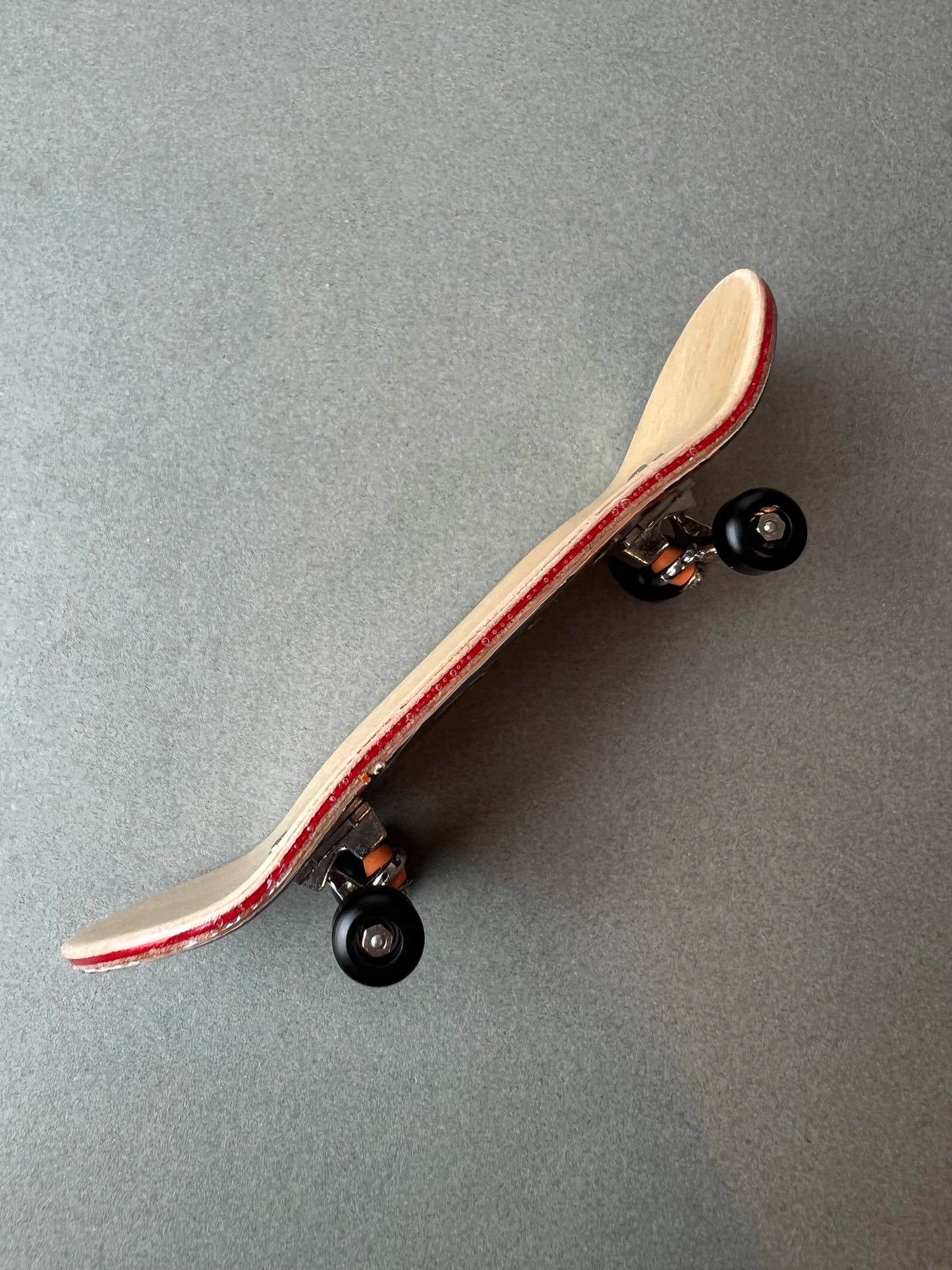 Dragon's Legacy de Finger3flip, fingerboard Pro de 34 mm de perfil, con la concavidad de la tabla y los ejes a la vista