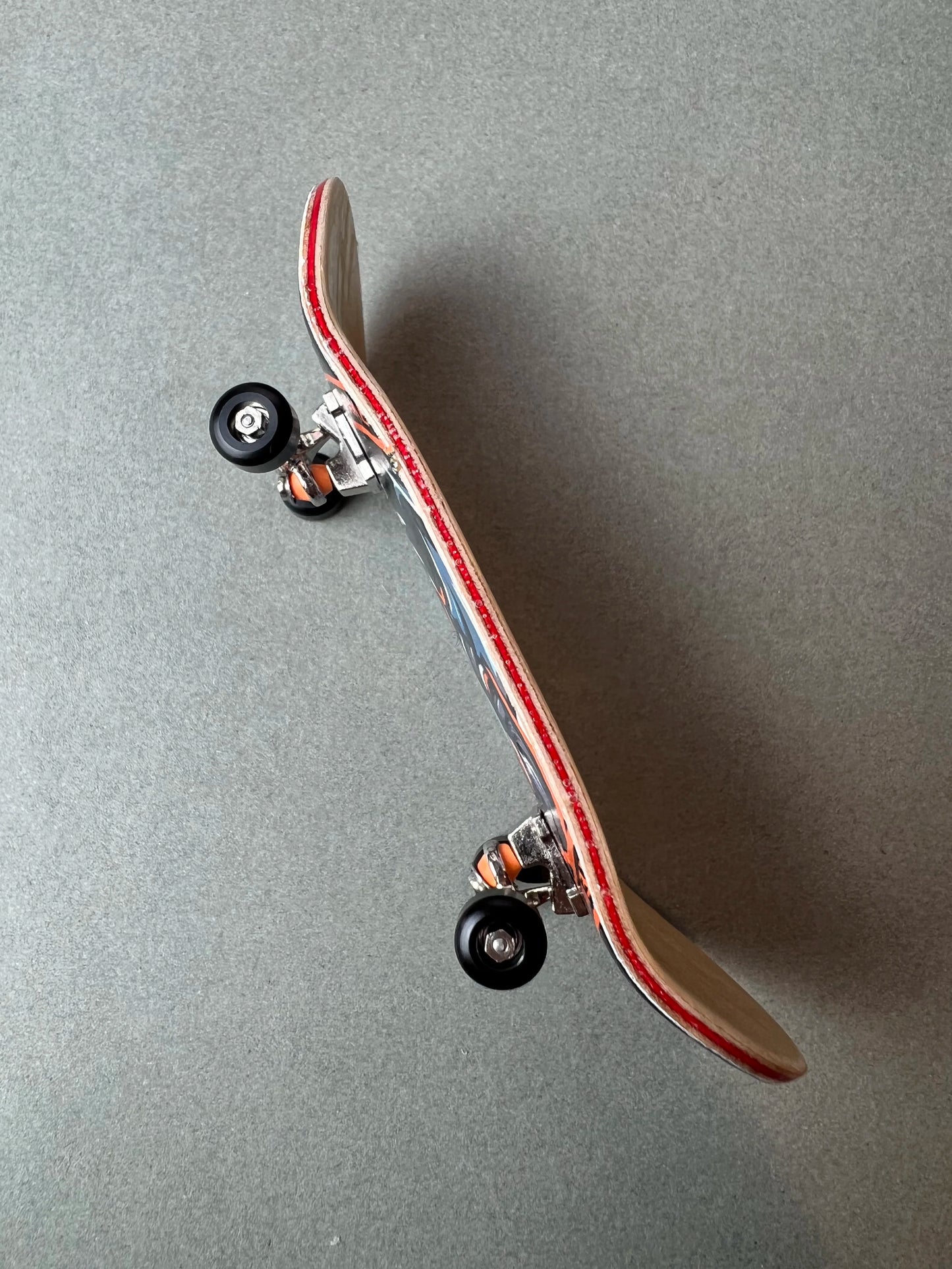 Dragon's Legacy de Finger3flip, fingerboard Pro de 34 mm inclinado, con los ejes y las ruedas en primer plano