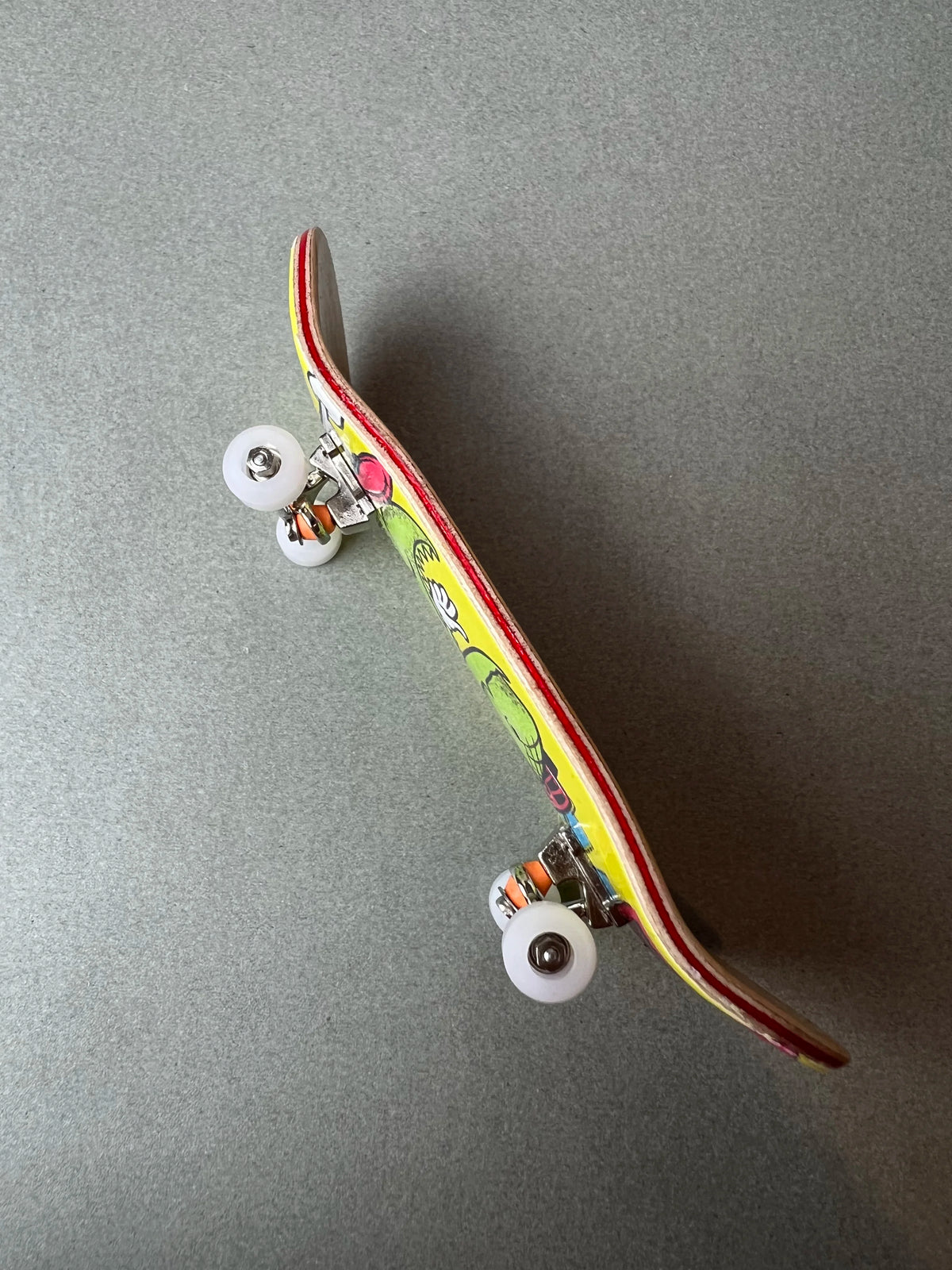 Wild Reptile de Finger3flip, fingerboard Pro de 34 mm inclinado, con los ejes y las ruedas en primer plano
