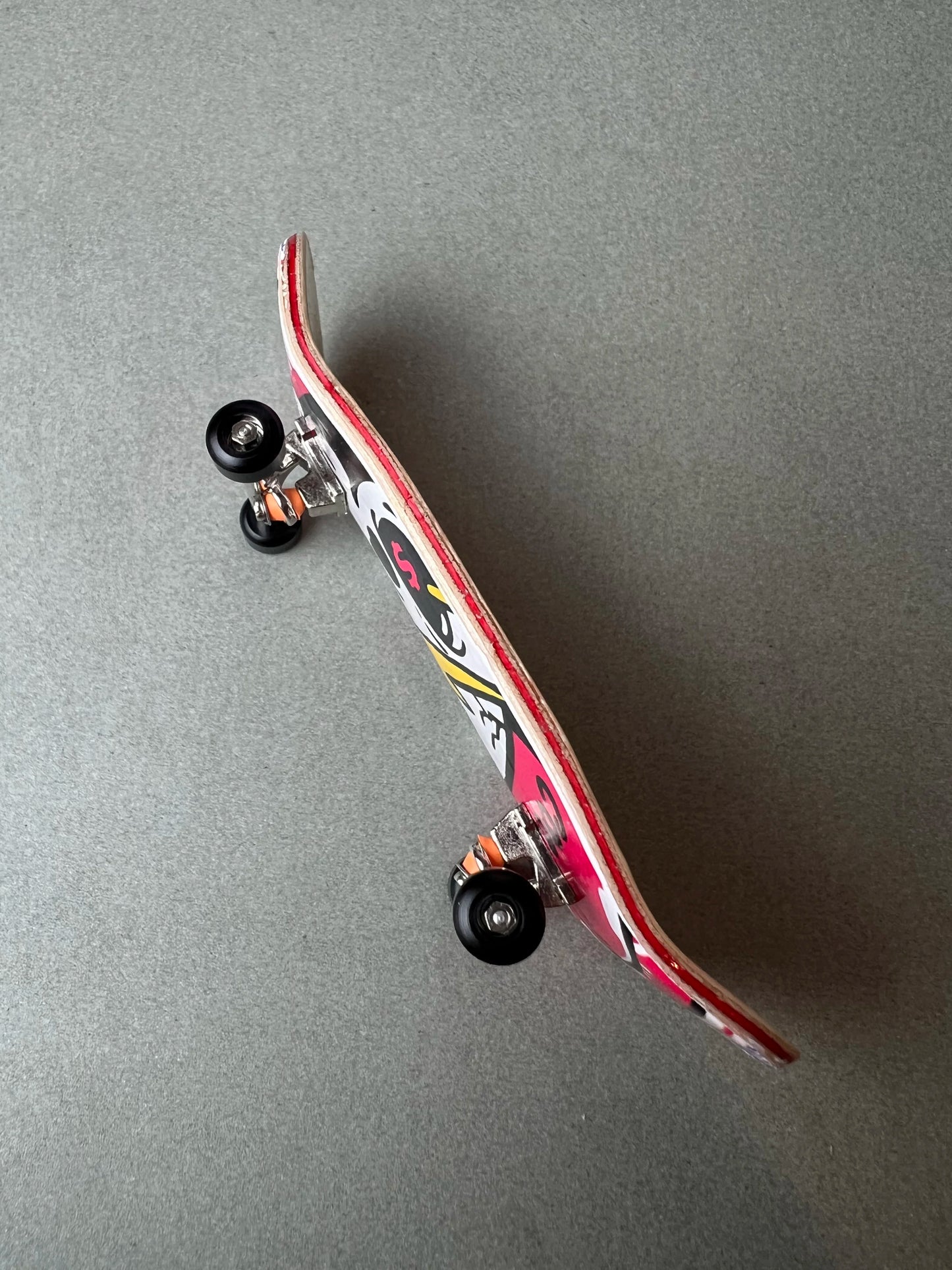 Death Gold de Finger3flip, fingerboard Pro de 34 mm inclinado, con los ejes y las ruedas en primer plano