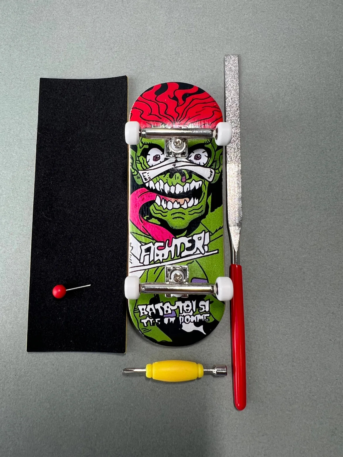 Jungle Fury de Finger3flip, fingerboard Pro de 34 mm montado visto desde arriba junto a grip, lija, llave y pin
