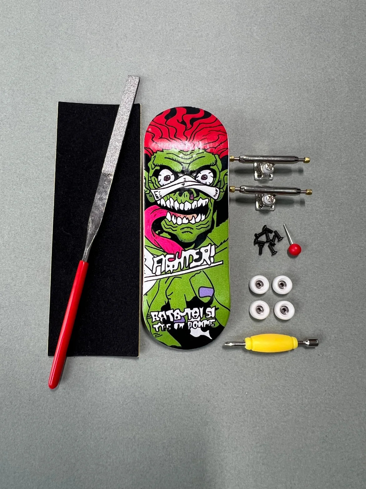 Kit Jungle Fury de Finger3flip desmontado desde arriba: tabla de 34 mm, ejes, ruedas, tornillos, grip, lija y llave